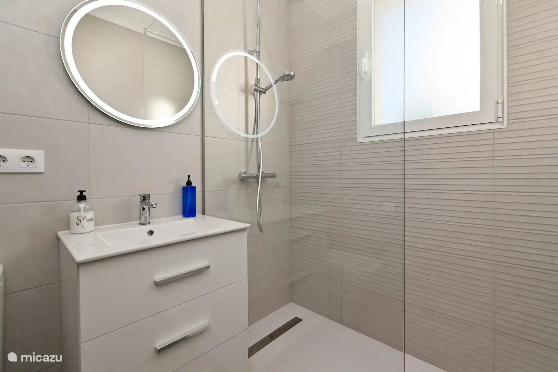 Salle de bain avec douche à effet pluie