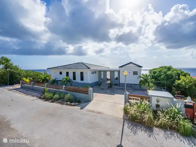 Votre propre station balnéaire privée CasAbao | Curaçao, Banda Abou (ouest), Cas Abao - villa Villa avec vue de face avec grand parking sur un terrain privé et sur la droite évier et porte-vêtements pour les plongeurs