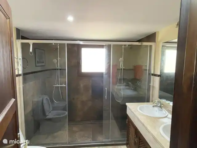 Finca San Antonio - Luxe Appartement huren in Spanje, Andalusië, Mijas - appartement De en-suite badkamer biedt een verfijnde combinatie van luxe en elegant design. Geniet van een verkwikkende douche onder de dubbele inloop regendouche, elegant afgescheiden door een glazen schuifwand.