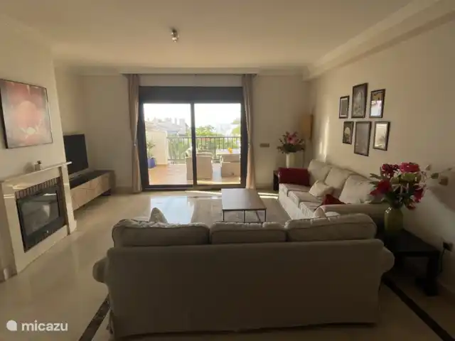 Finca San Antonio - Luxe Appartement huren in Spanje, Andalusië, Mijas - appartement De woonkamer is ruim en heerlijk licht, met een panoramisch uitzicht dat zich uitstrekt tot aan de zee in de verte. Dankzij de grote schuifdeuren loopt de woonkamer naadloos over in het riante terras