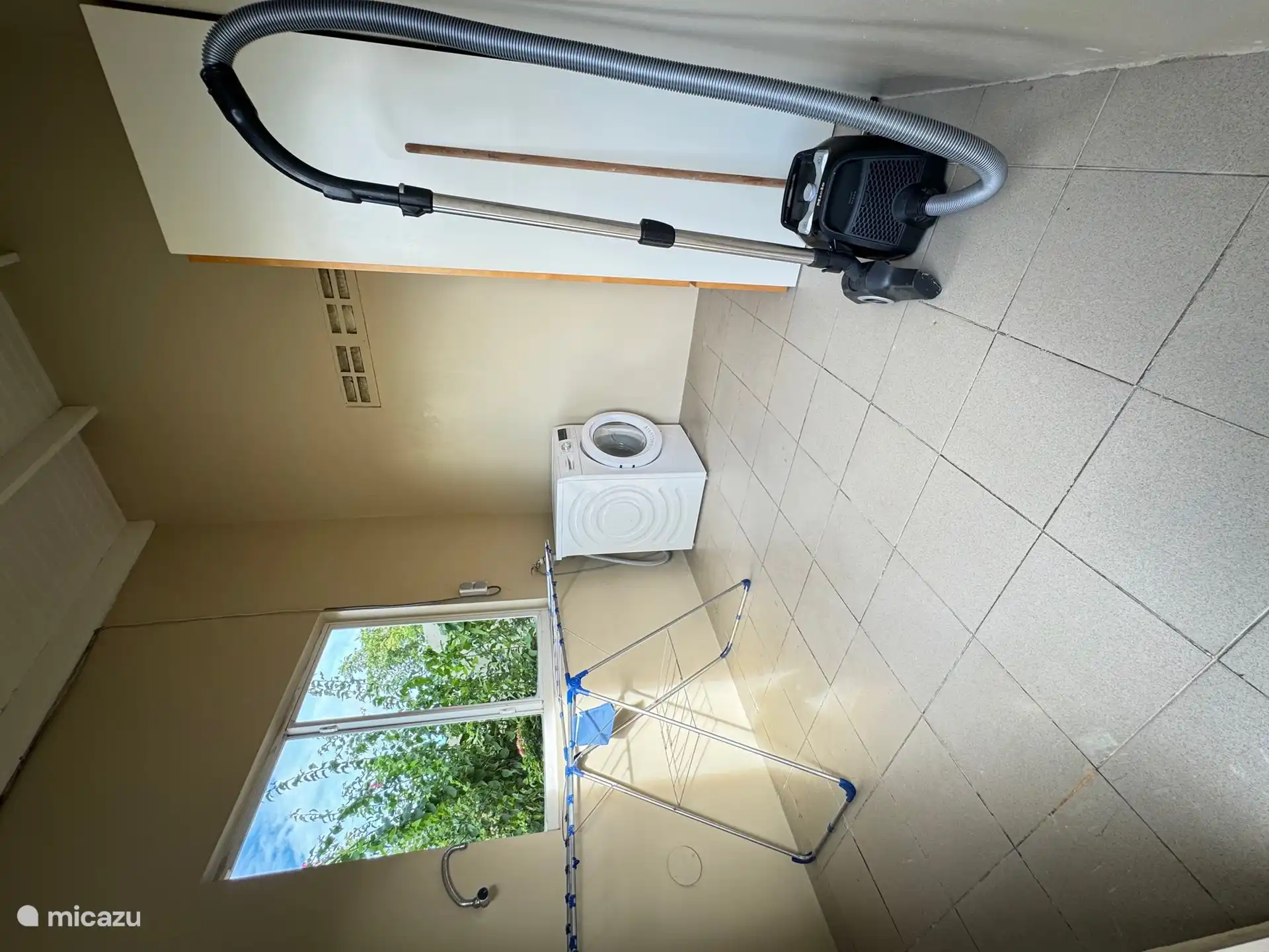 Buanderie avec machine à laver, aspirateur, planche à repasser, fer à repasser et étendoir