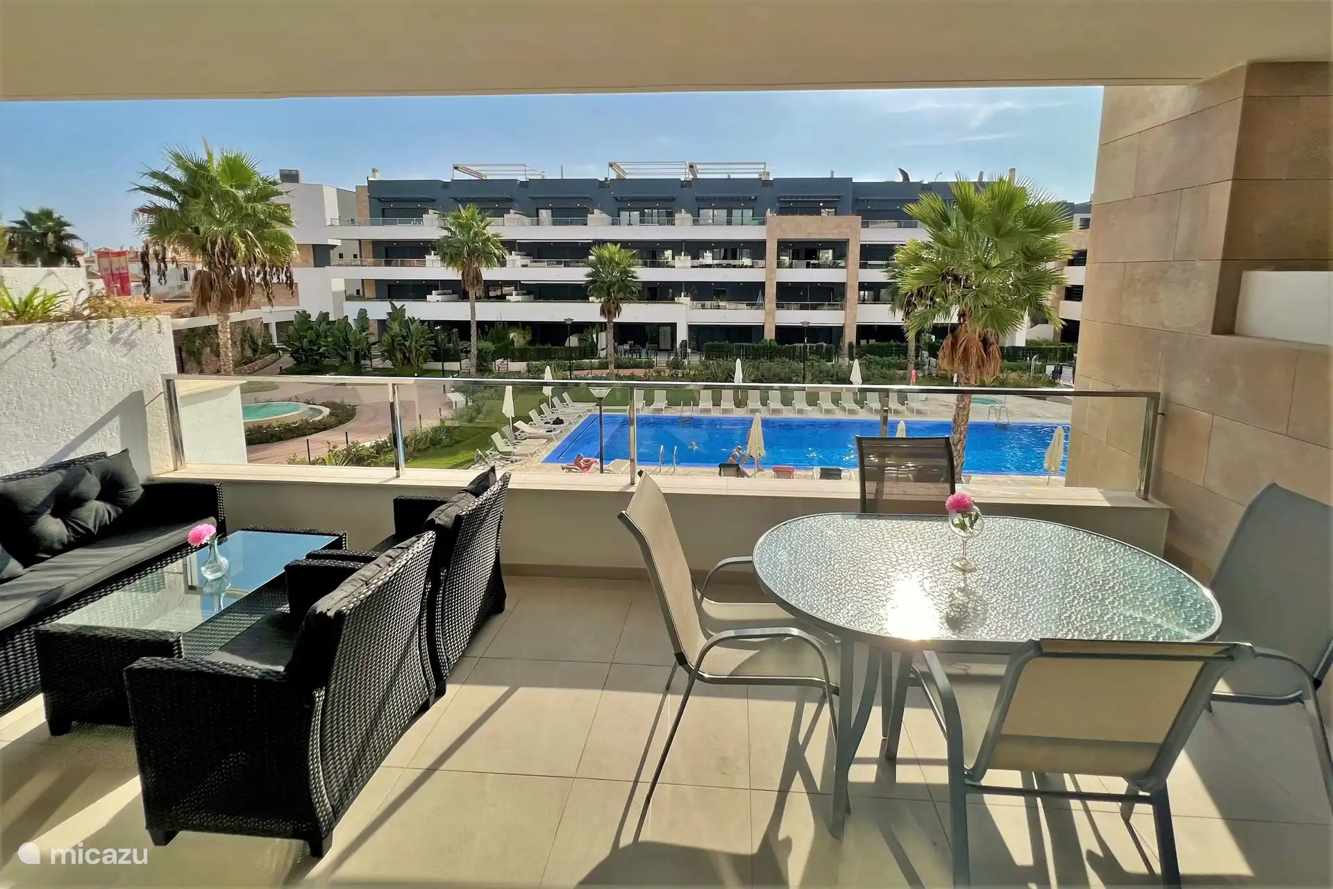 Large balcony with lounge set and dining table