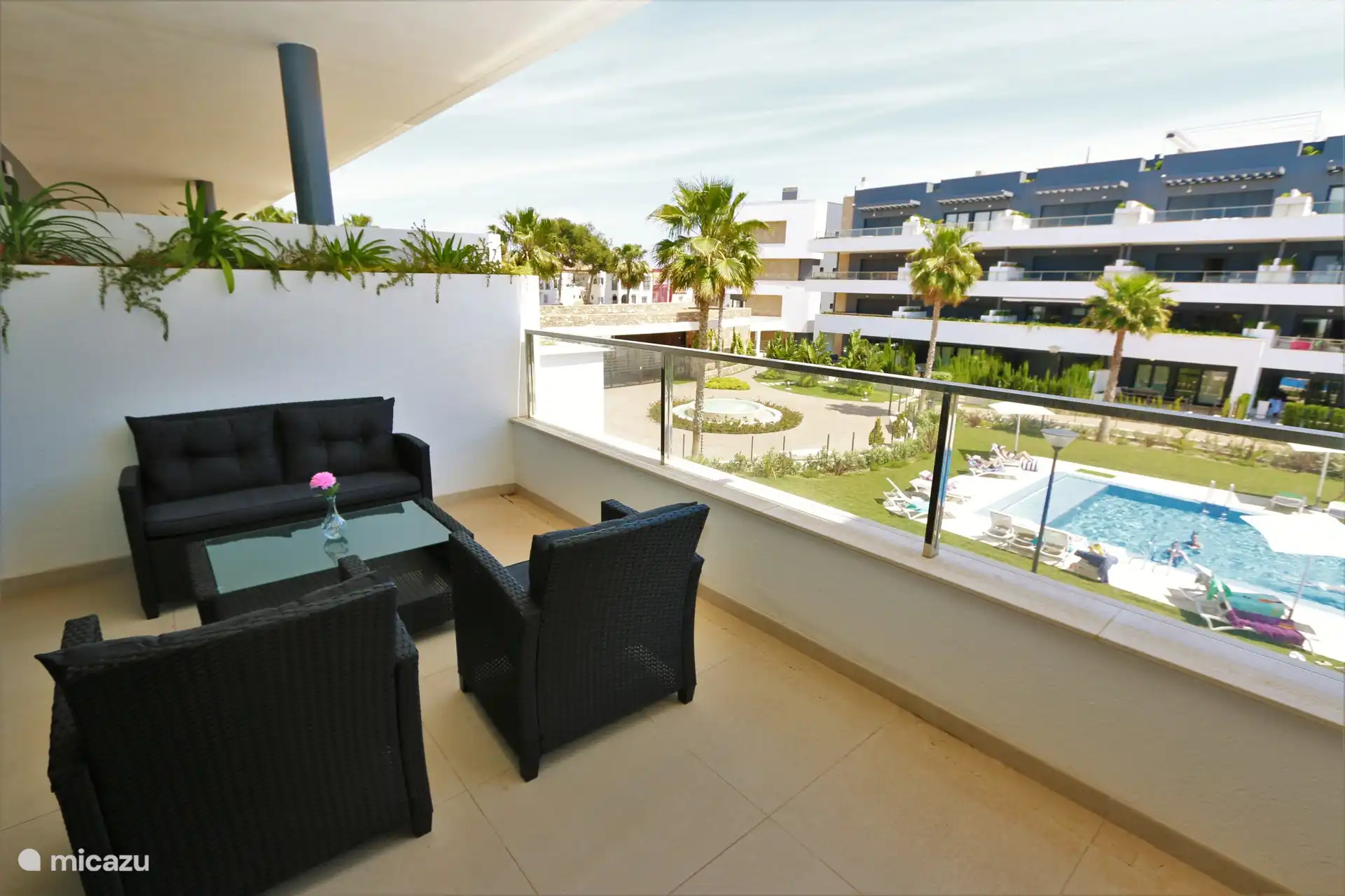 Large balcony with lounge set and dining table
