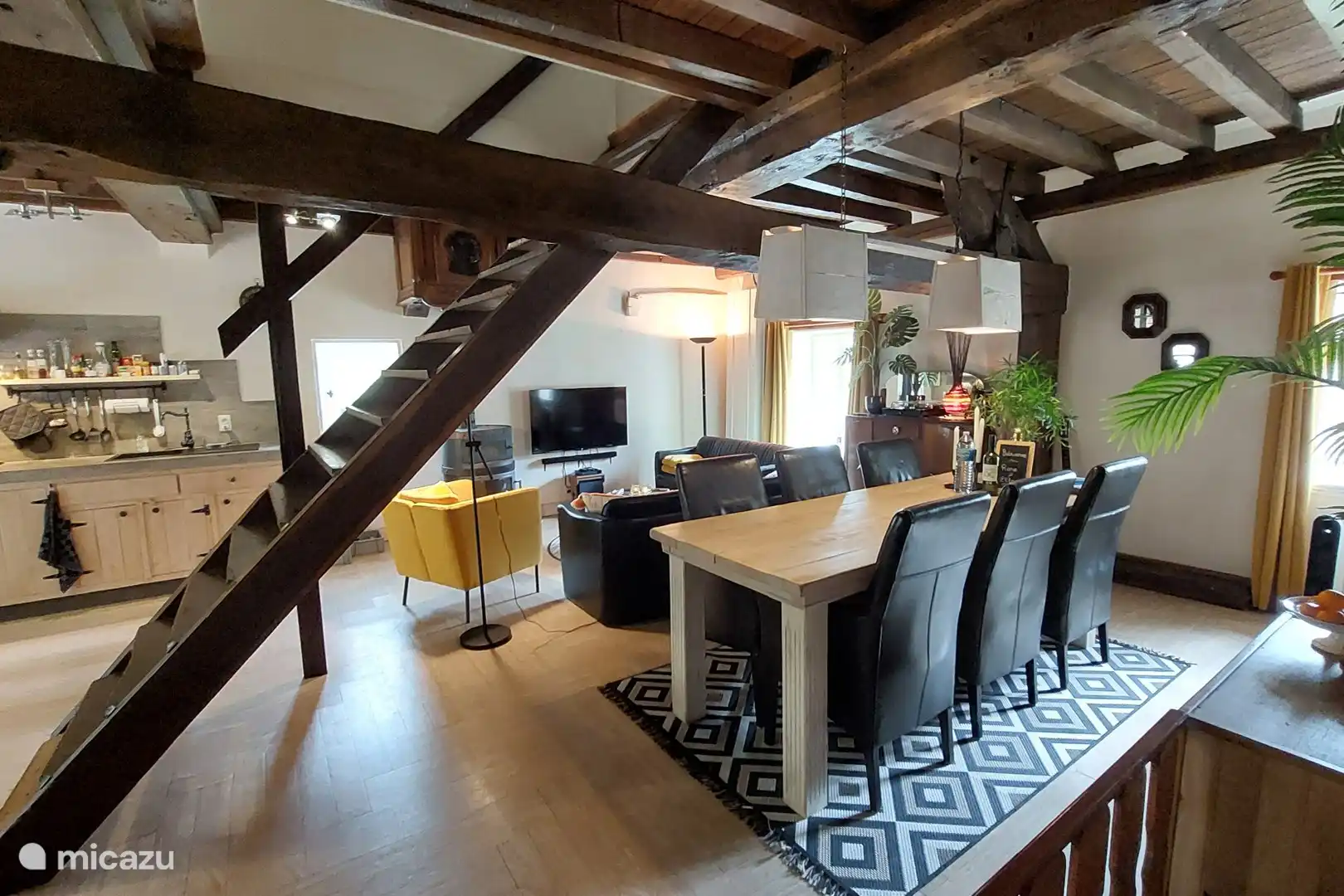 Gemütliches Wohnzimmer mit offener Küche, Sitzecke und großem Esstisch