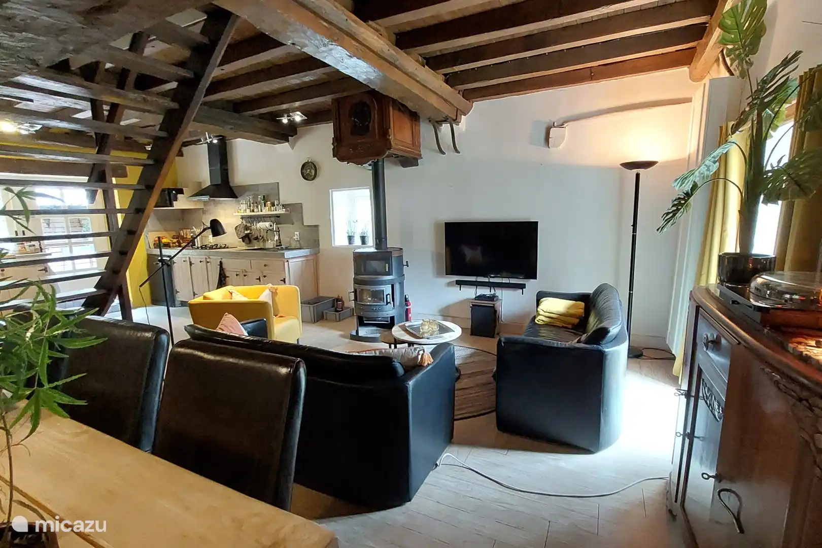 Gemütliches Wohnzimmer mit offener Küche, Sitzecke und großem Esstisch