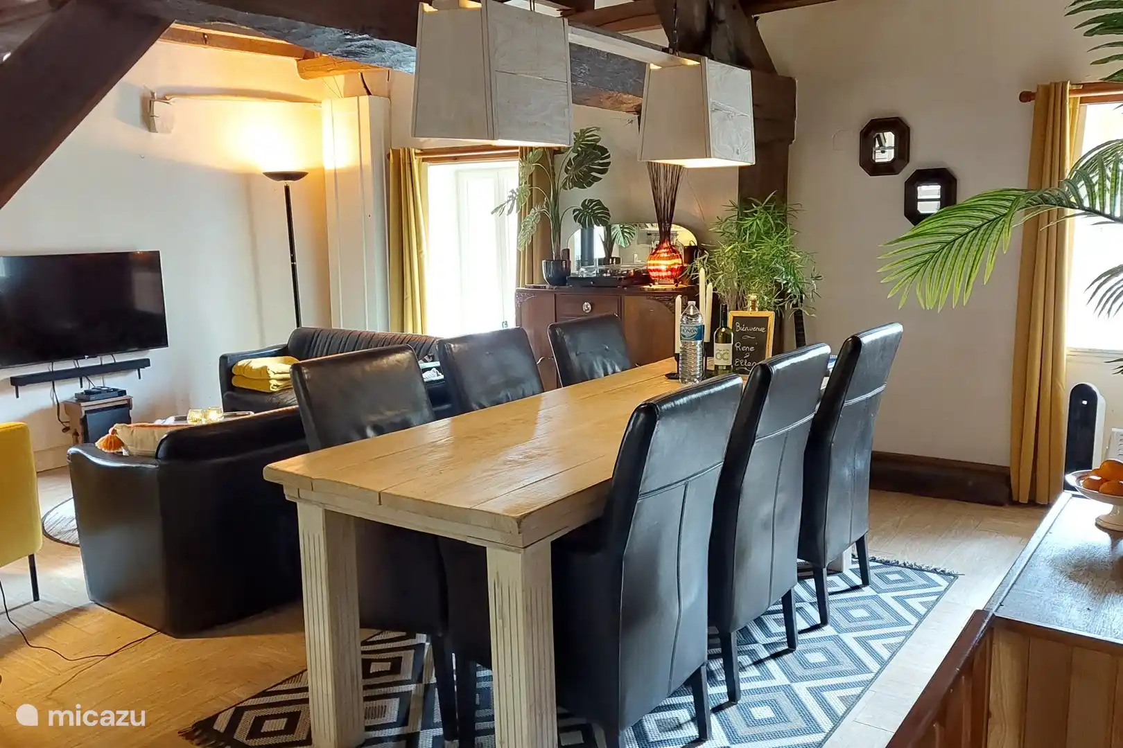 Gemütliches Wohnzimmer mit offener Küche, Sitzecke und großem Esstisch