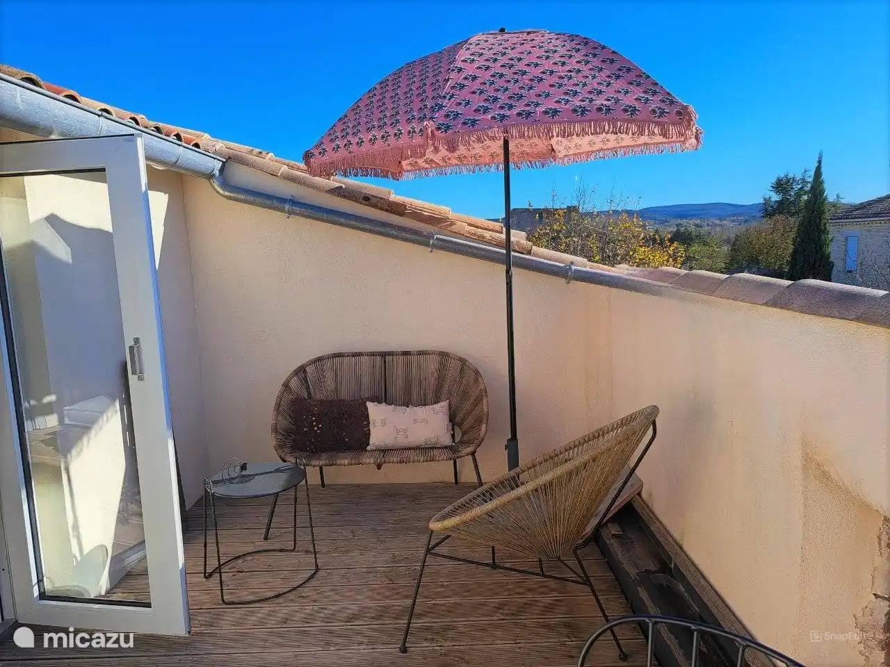 Private Terrasse mit Sitzgelegenheiten und Sonnenschirm