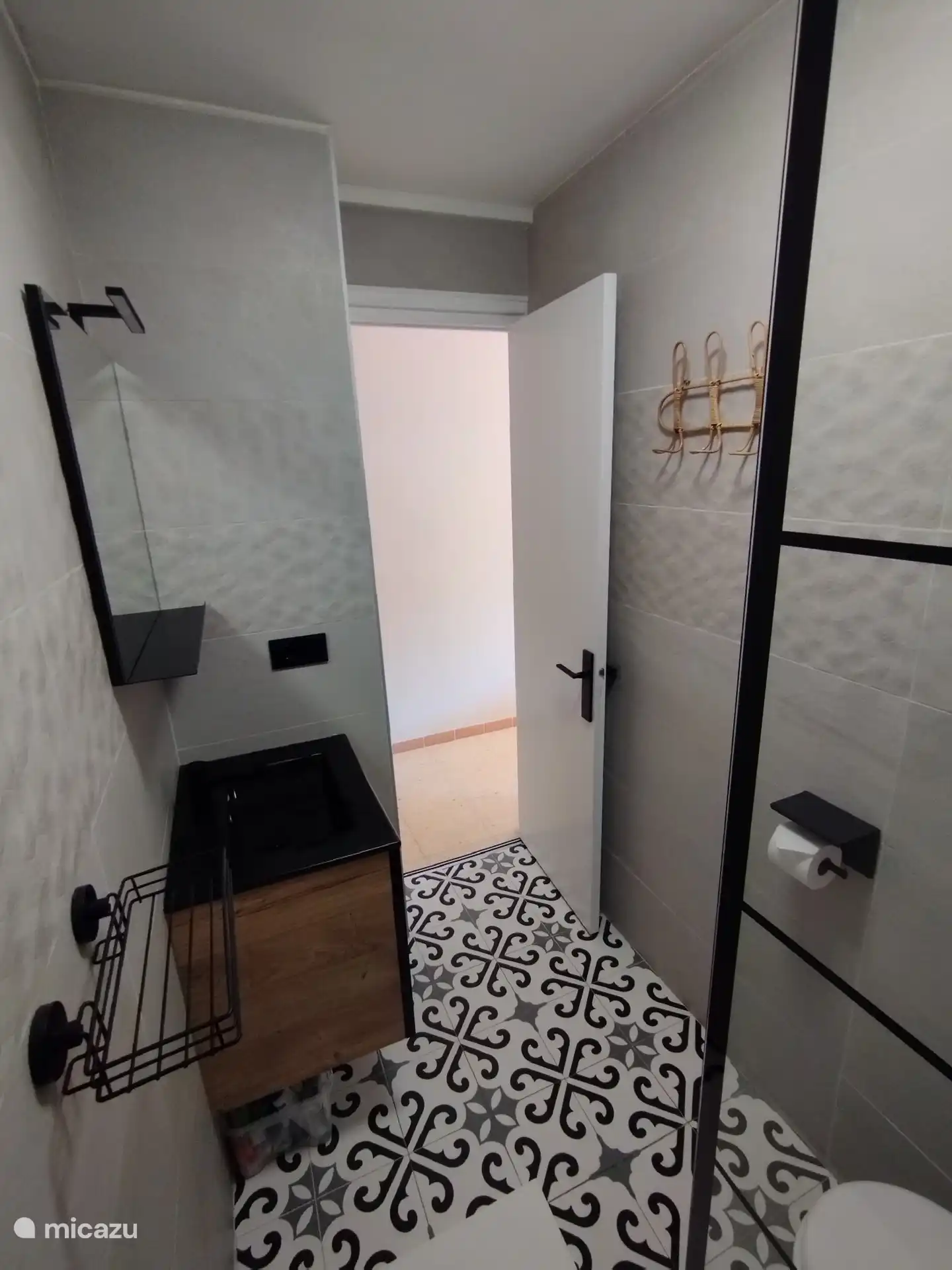 De badkamer heeft een regendouche, hangtoilet en een wasmeubel met 2 laden.