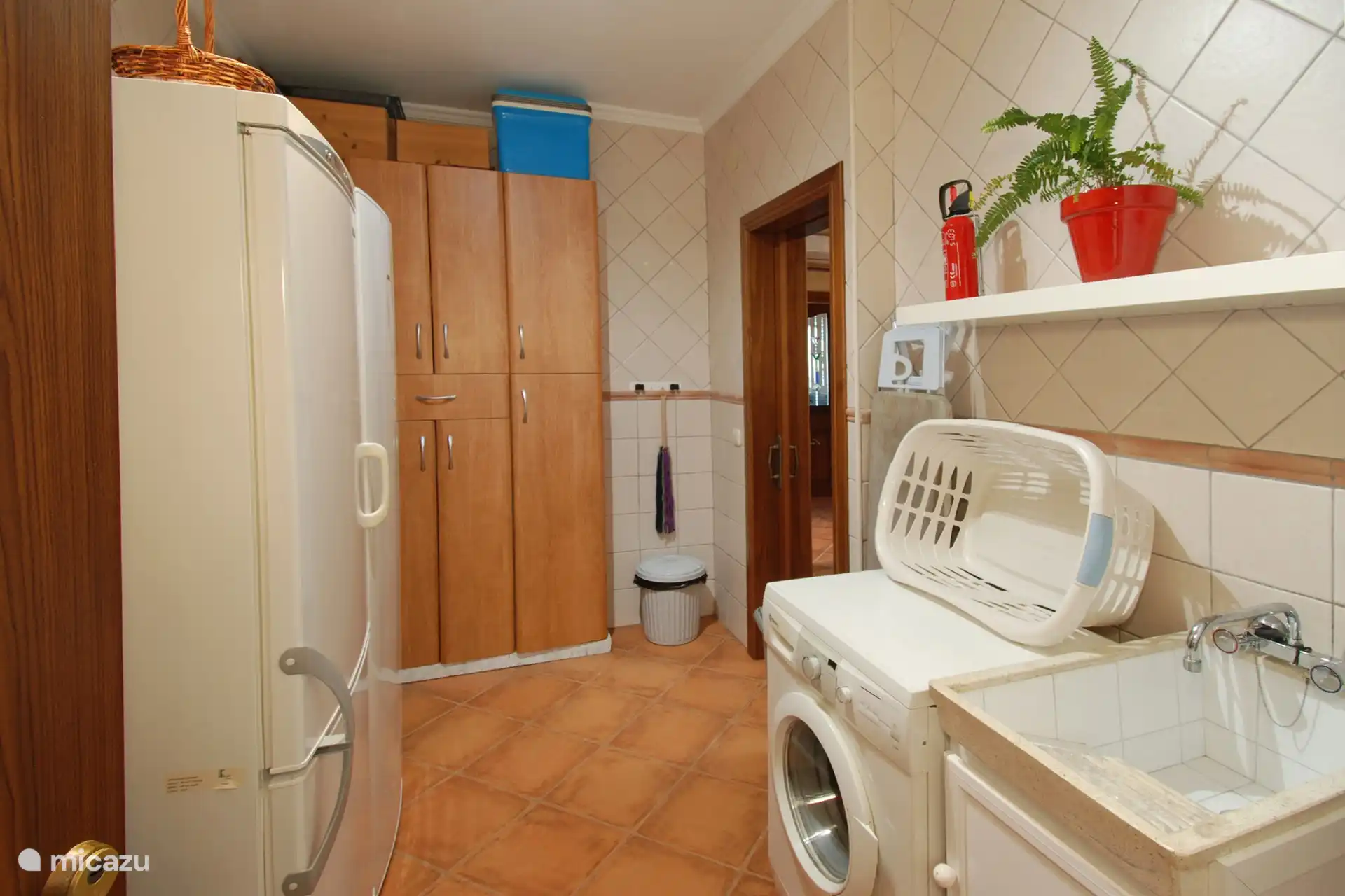 Viel Stauraum, eine Waschmaschine und Bügeleisen/-brett im Hauswirtschaftsraum. 