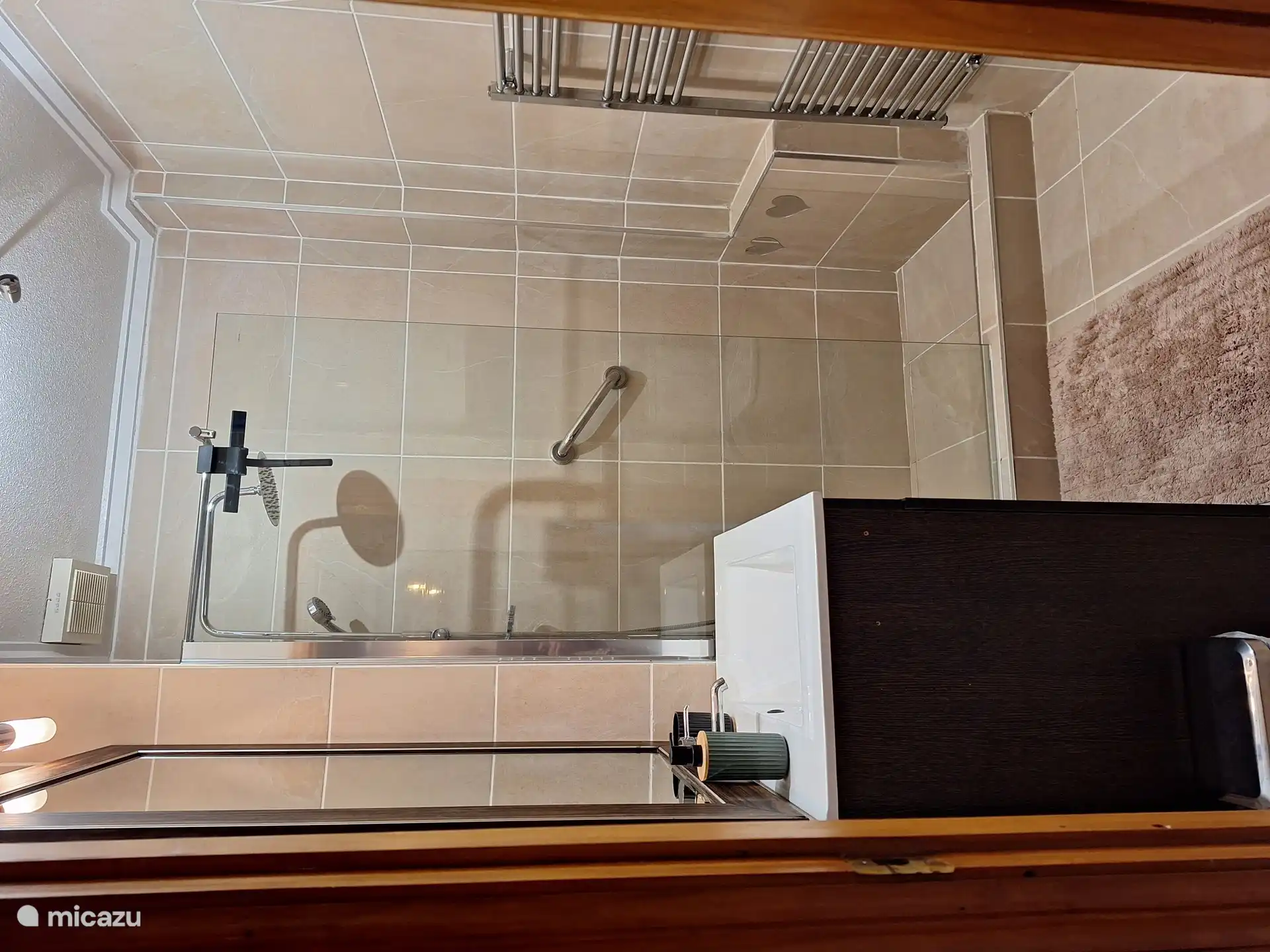 Badezimmer mit ebenerdiger Dusche, Waschbecken und Handtuchtrockner