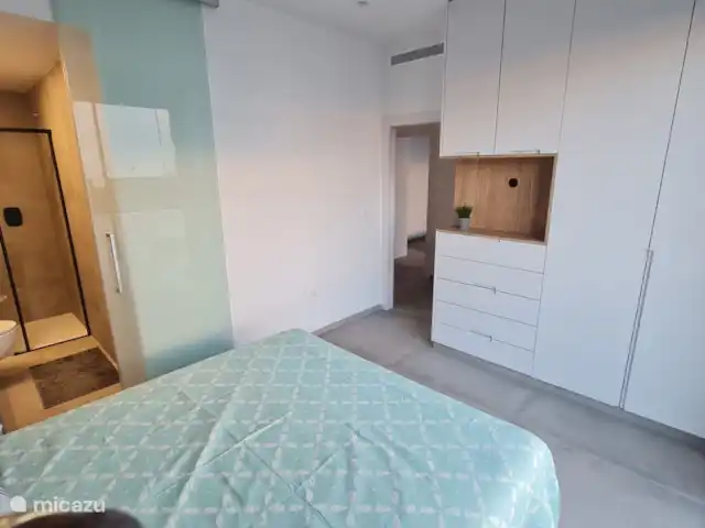 Casa Sol Y Mar | Espagne, Murcia, San Pedro del Pinatar - appartement Chambre principale avec armoire encastrée et porte coulissante en verre vers la salle de bain attenante.