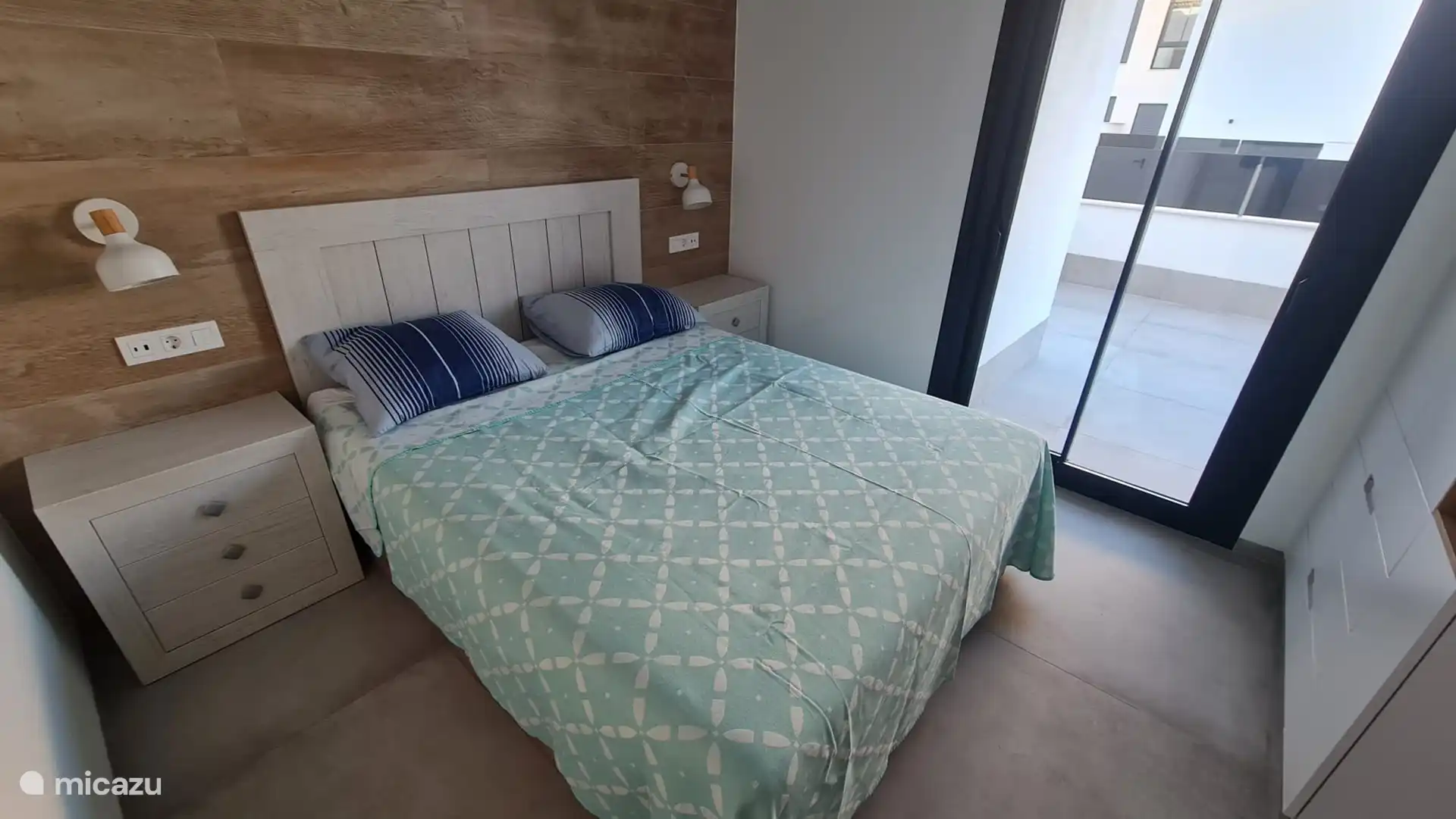 Deuxième chambre avec portes coulissantes et vue sur la rue.