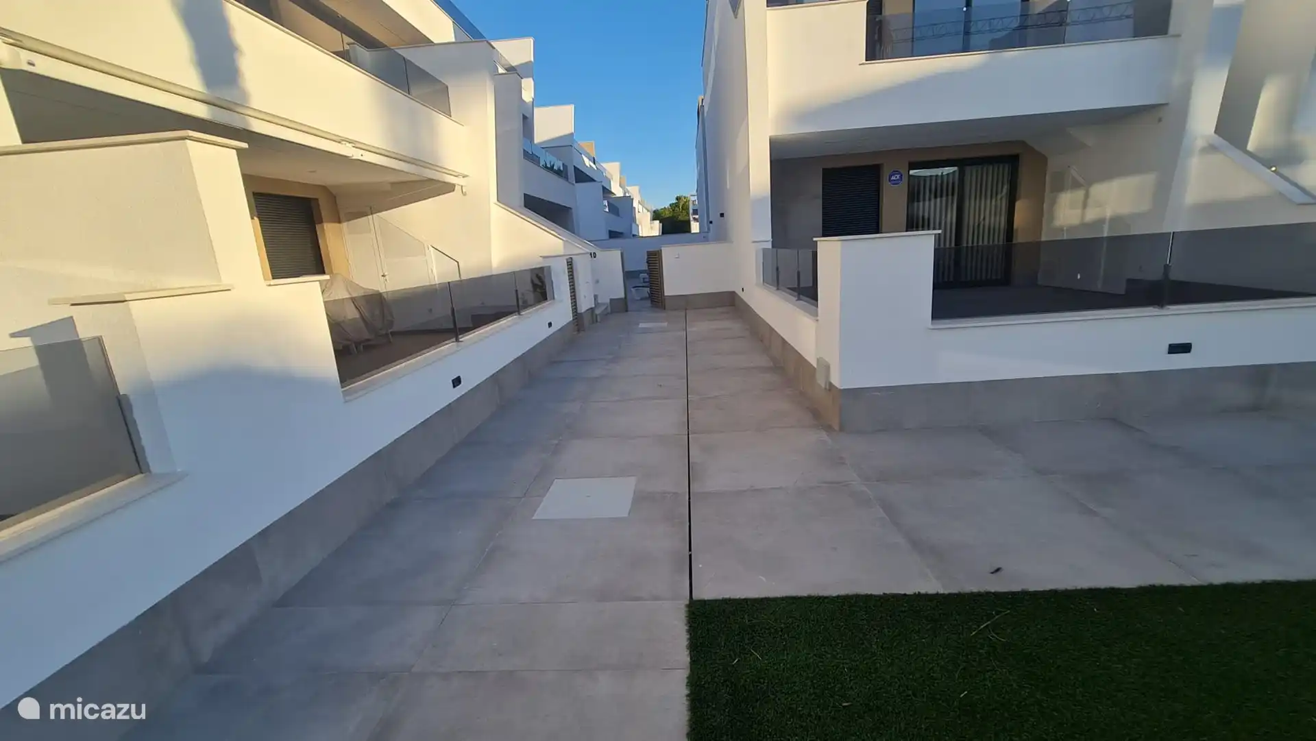 Vue depuis la piscine. Porte d’accès terrasse appartement. 