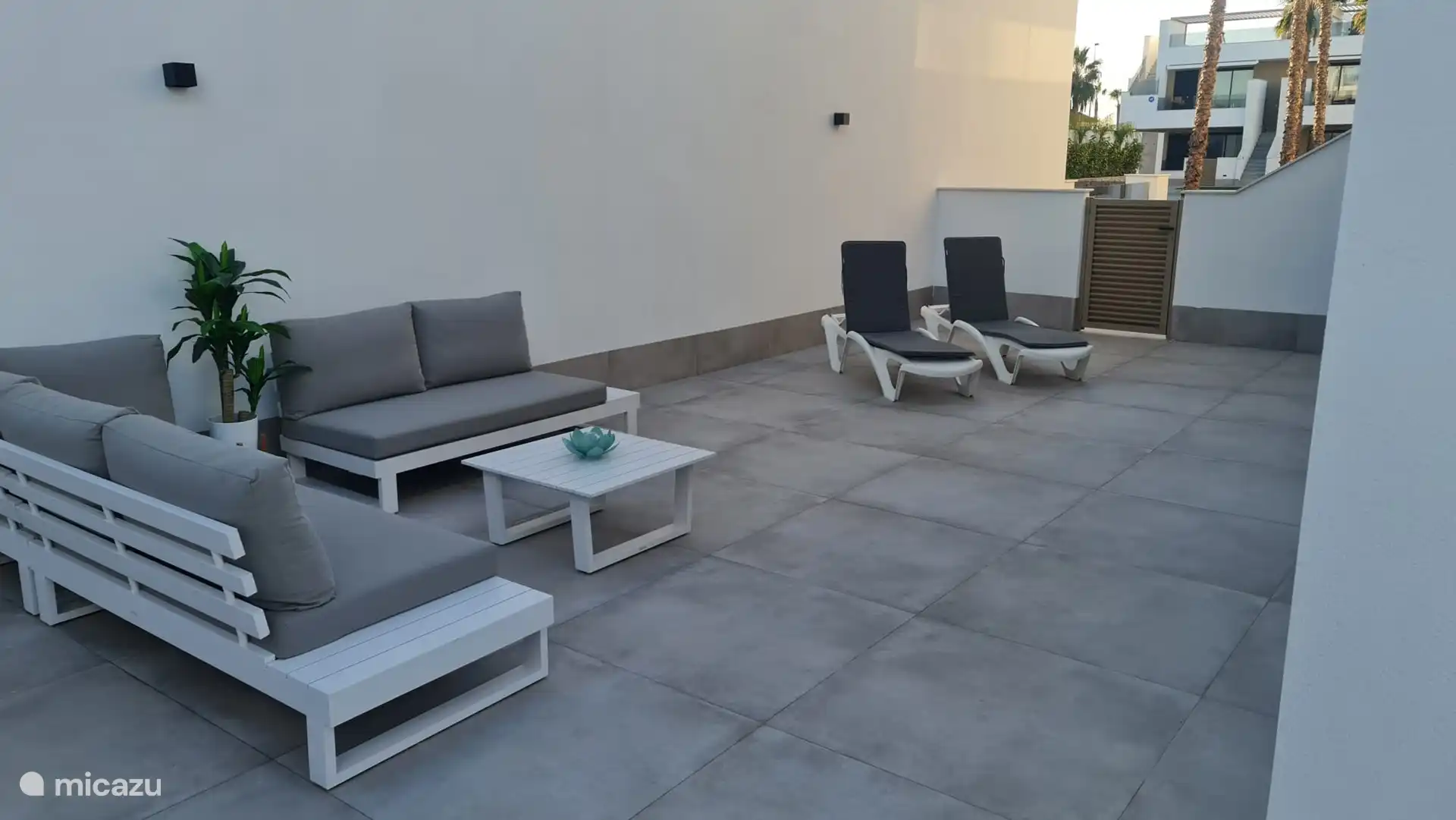 Porte d’entrée vers la piscine. Grande terrasse avec transats. 