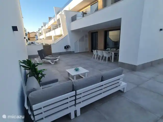 Casa Sol Y Mar | Espagne, Murcia, San Pedro del Pinatar - appartement Photo d’ensemble de la terrasse avec salon et table à manger. Porte qui donne accès à la piscine commune. Machine à laver disponible dans le débarras à l’extérieur.