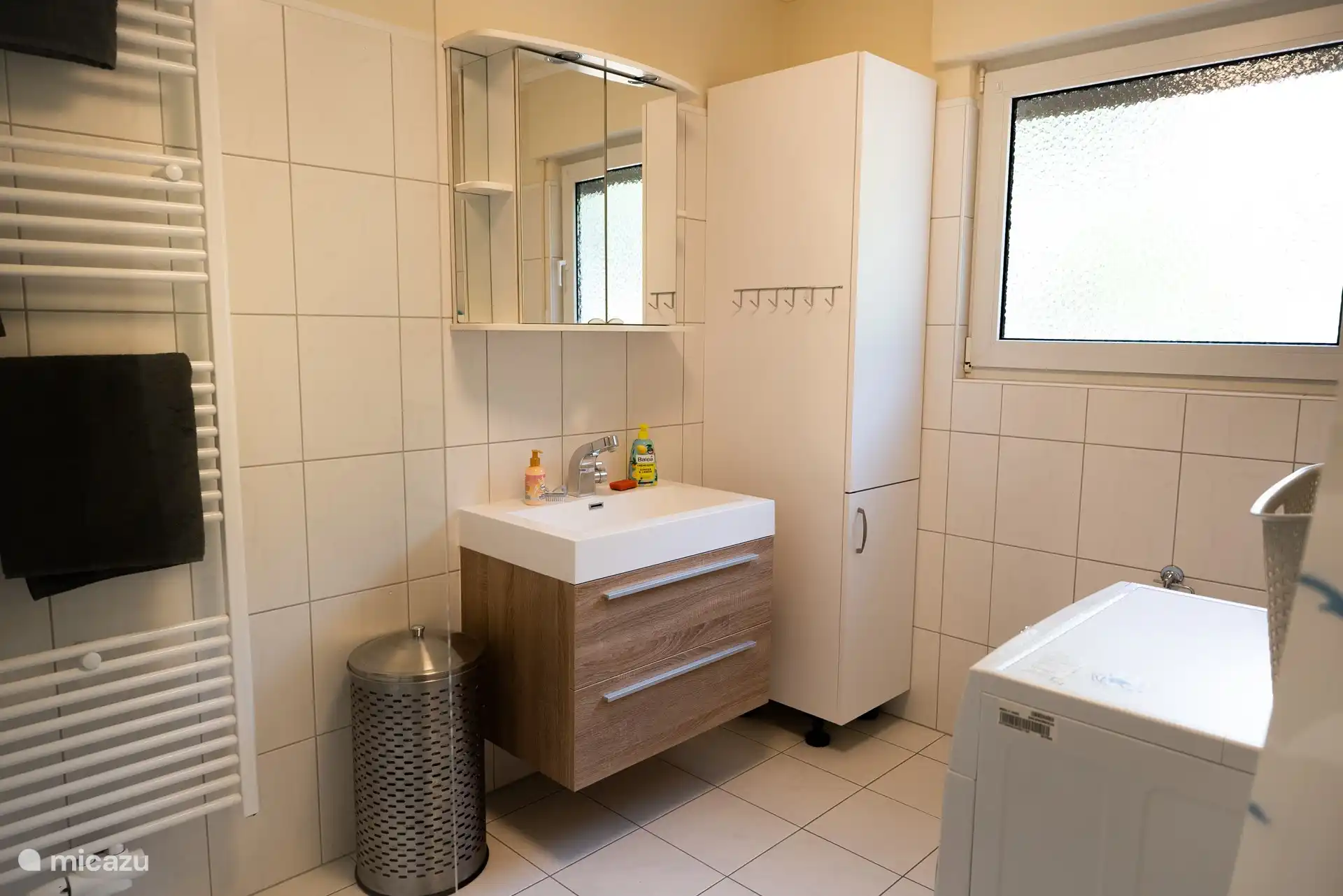Bathroom with wash dryer, towel warmer, raised toilet, hair dryer