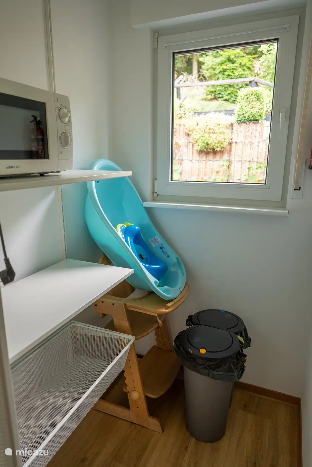 Storage room Kitchen with high chair, bathtub, stool, microwave
