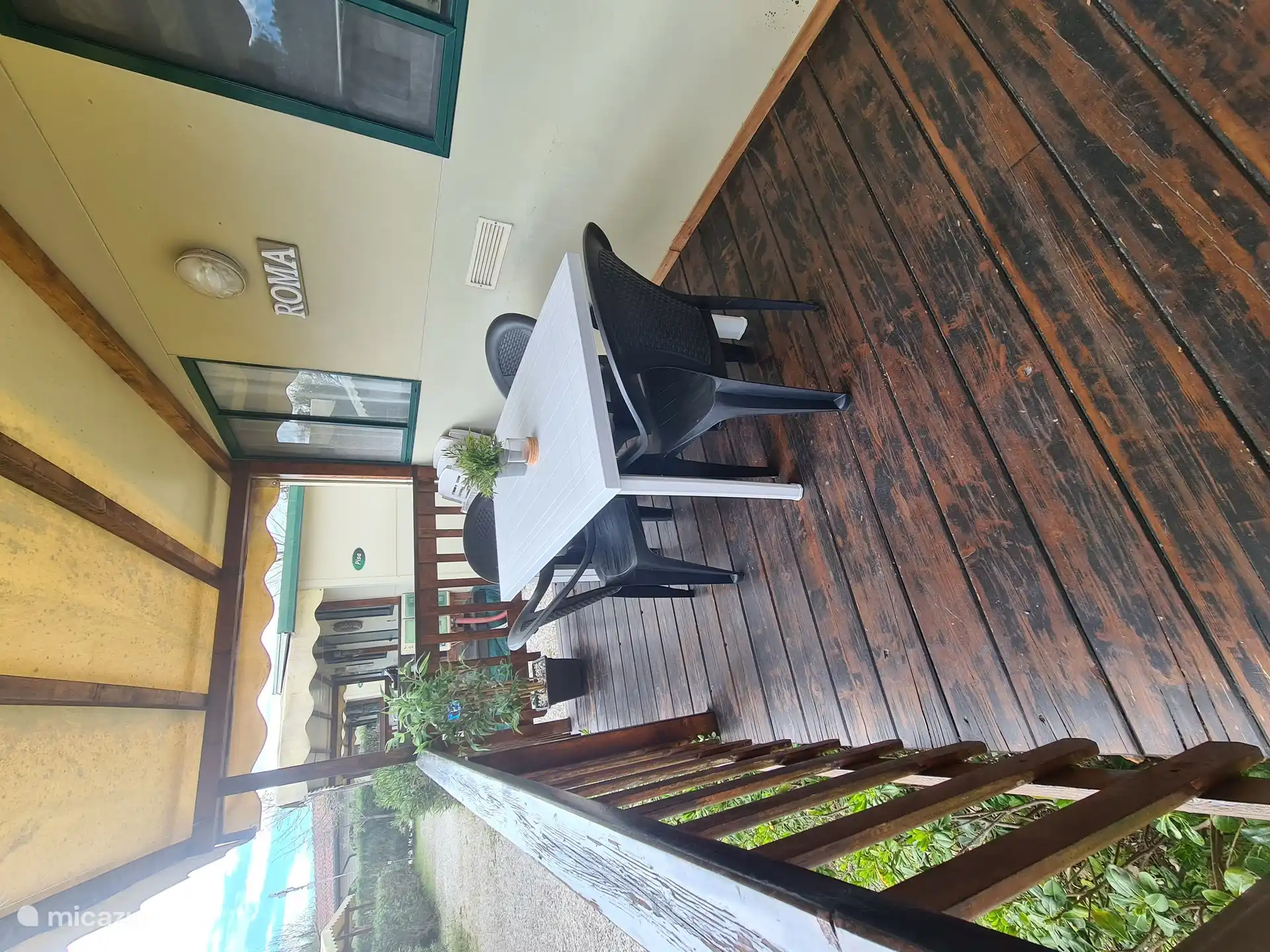 Die große überdachte Veranda verfügt auch über einen Esstisch.