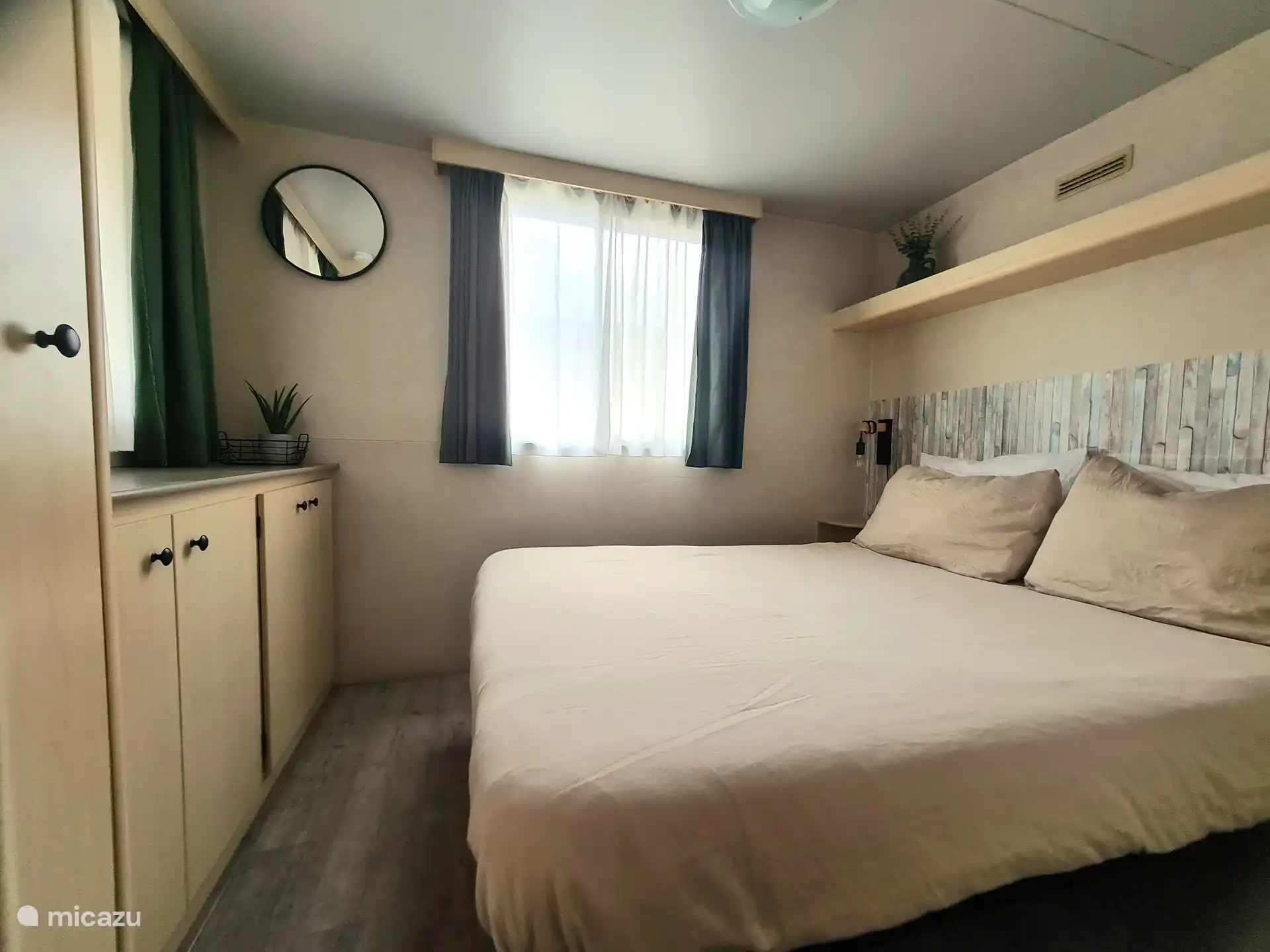 Das Schlafzimmer mit Doppelbett und viel Stauraum.