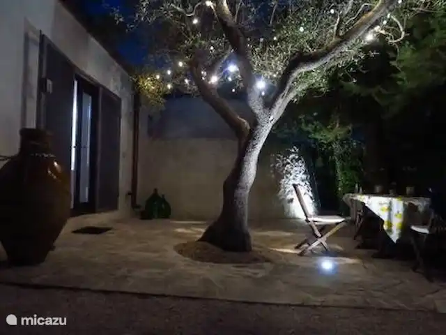 Antiguo Trullo Casa Lucca en Italia, Apulia, Carovigno - casa vacacional Asiento bajo los árboles noche / puerta de entrada