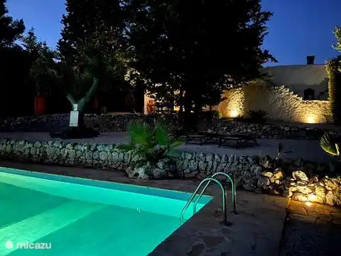 Piscina y fachada por la noche