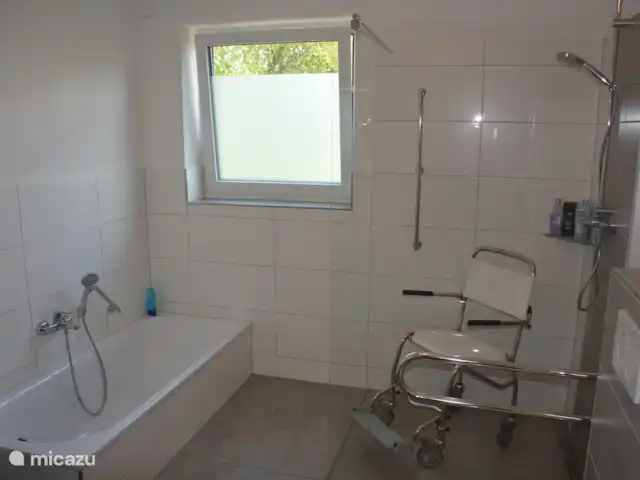 Maison de vacancesWinterberg max 16 pers | Allemagne, Sauerland, Winterberg - maison de vacances La salle de bain au rez-de-chaussée est adaptée aux fauteuils roulants, avec baignoire et douche à l’italienne et toilettes séparées. Des barres d’appui et une chaise de douche sont fournies.