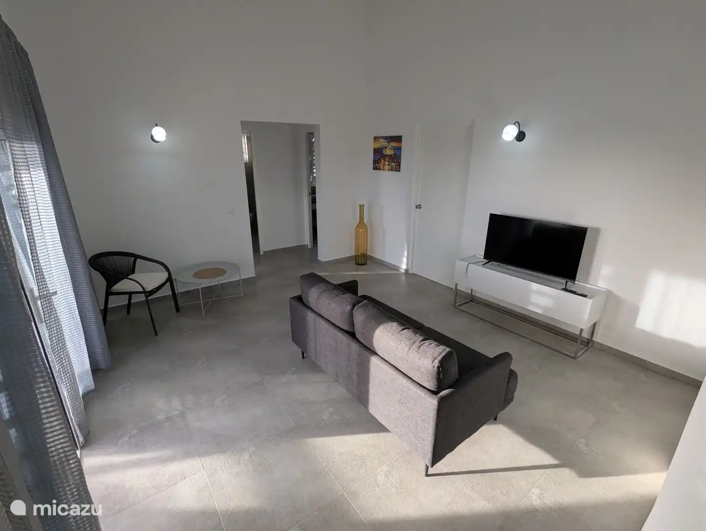 Binnen woonkamer, zicht op de tweede en derde slaapkamer en de grote badkamer