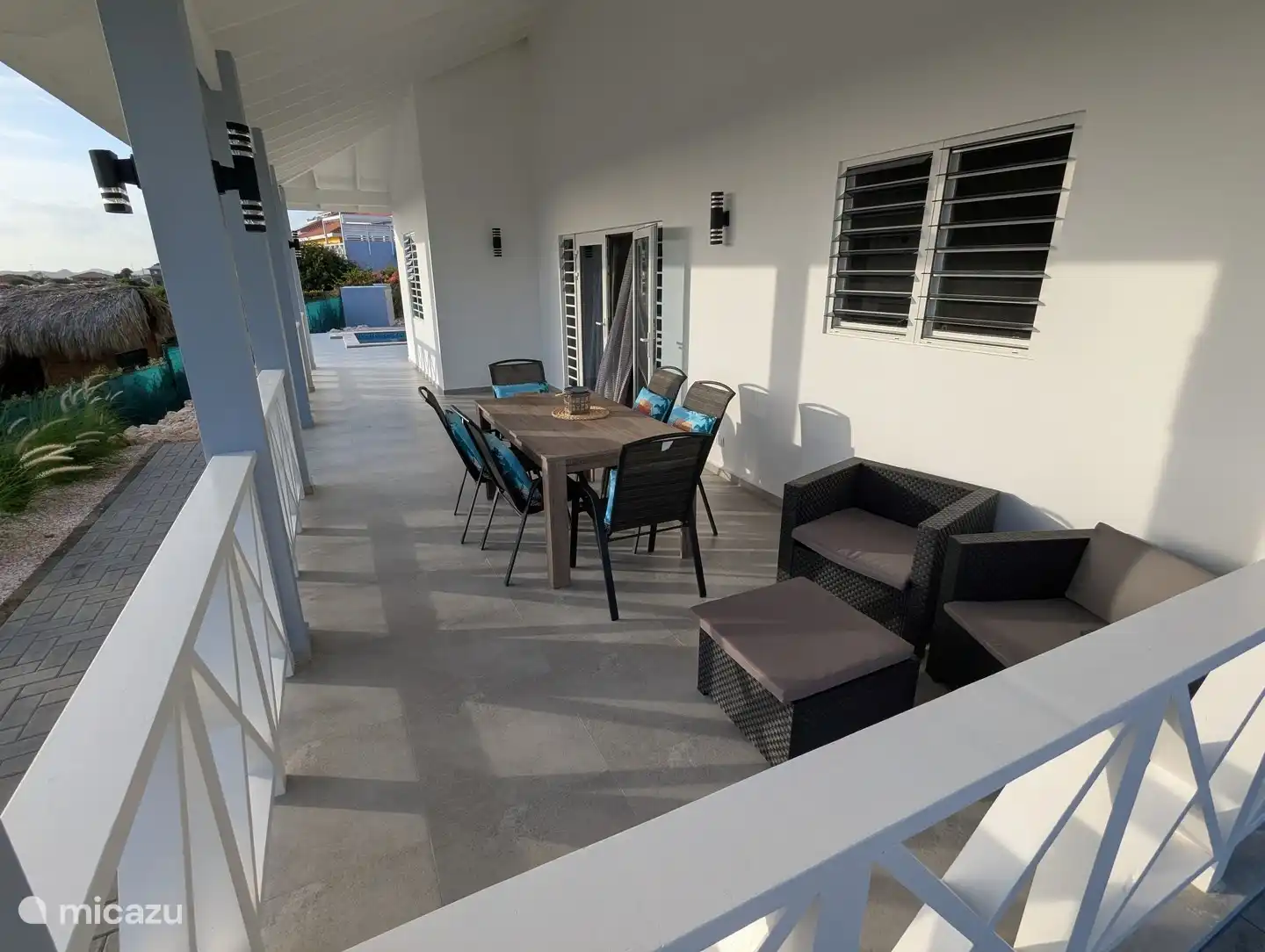 Hoofdveranda aan de voorzijde en hoofdingang, met eethoek buiten en extra zitplaatsen