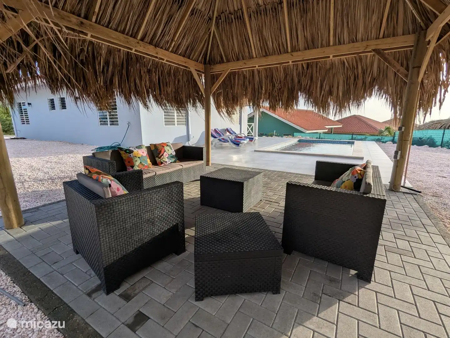 Comfortabele zithoek onder de palapa naast het zwembad
