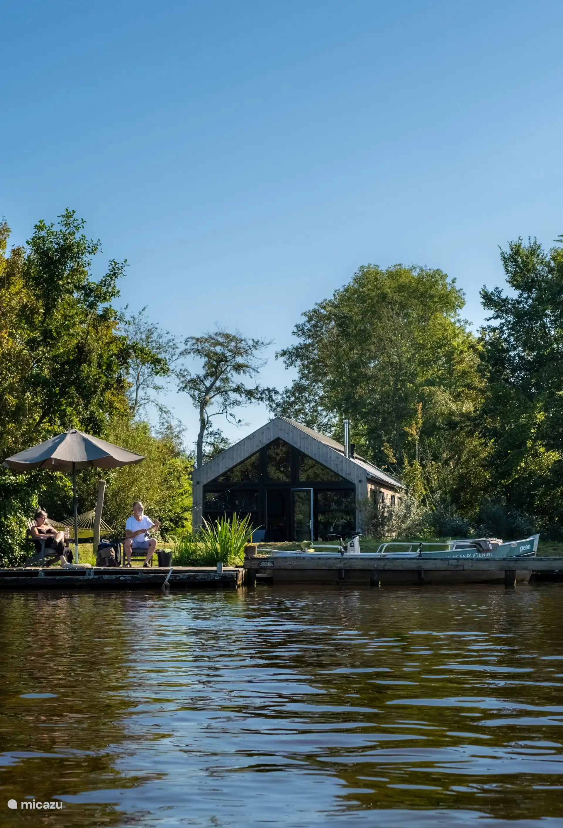 De lodge en de eigen steiger vanaf het water