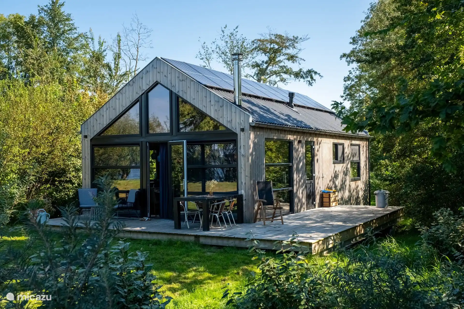 De lodge met terras aan de tuinzijde