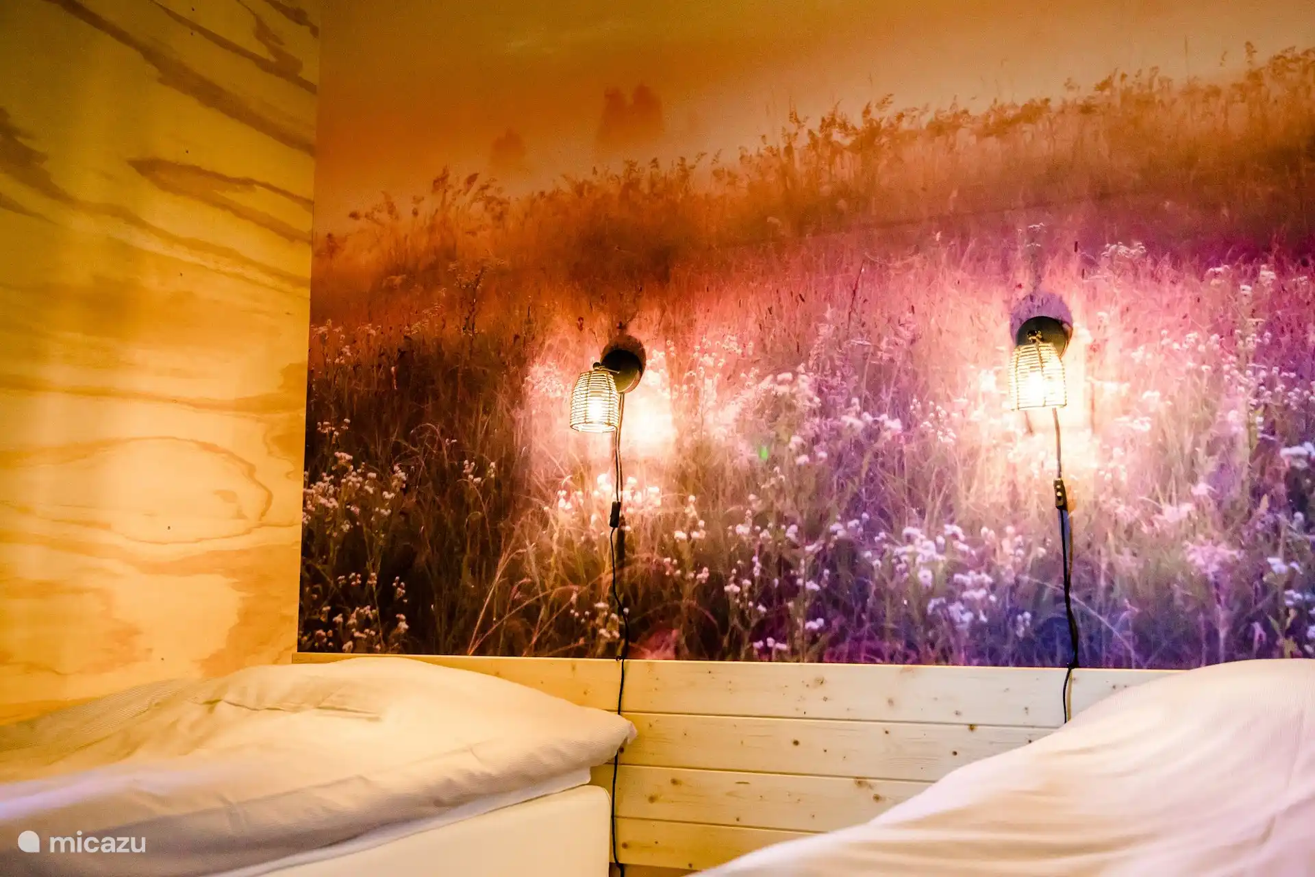 Slaapkamer met tweepersoonsbed en een sfeervol behang.