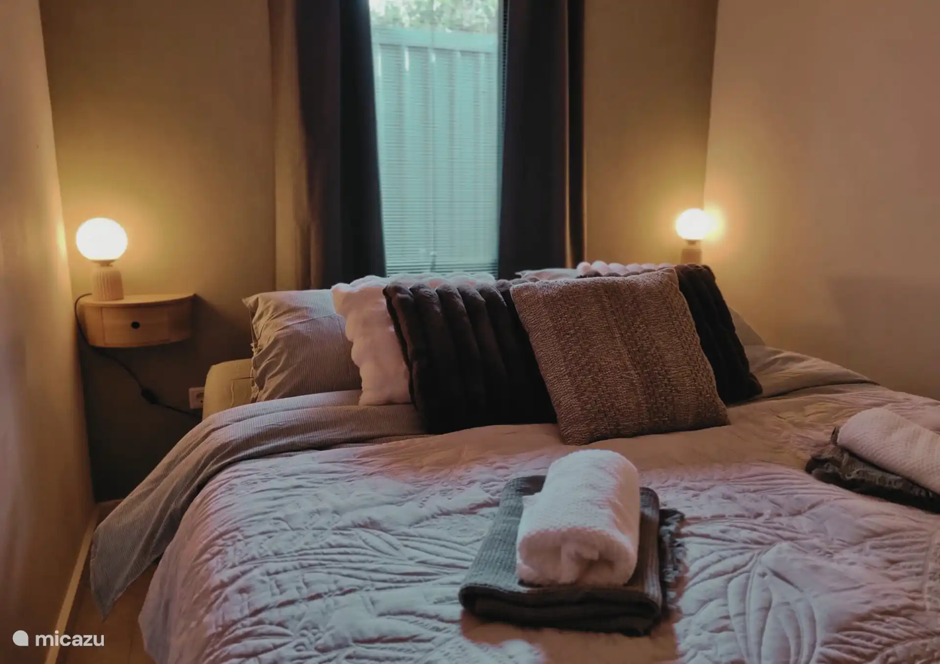 Das gemütlich gemachte Bett mit den Nachtlichtern im Hauptschlafzimmer