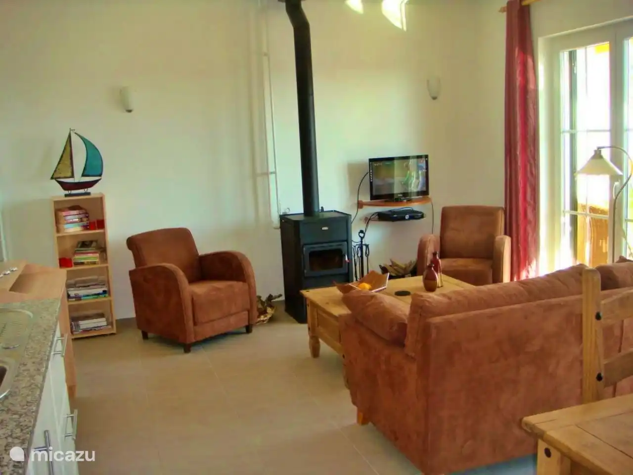 Das Wohnzimmer mit Holzofen und TV