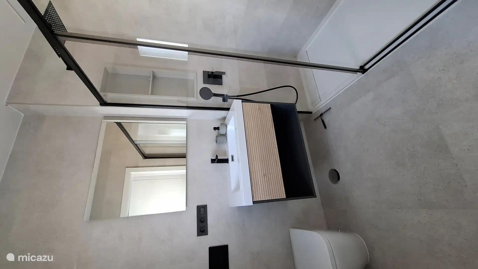 Segundo baño con ducha a ras de suelo, lavabo e inodoro