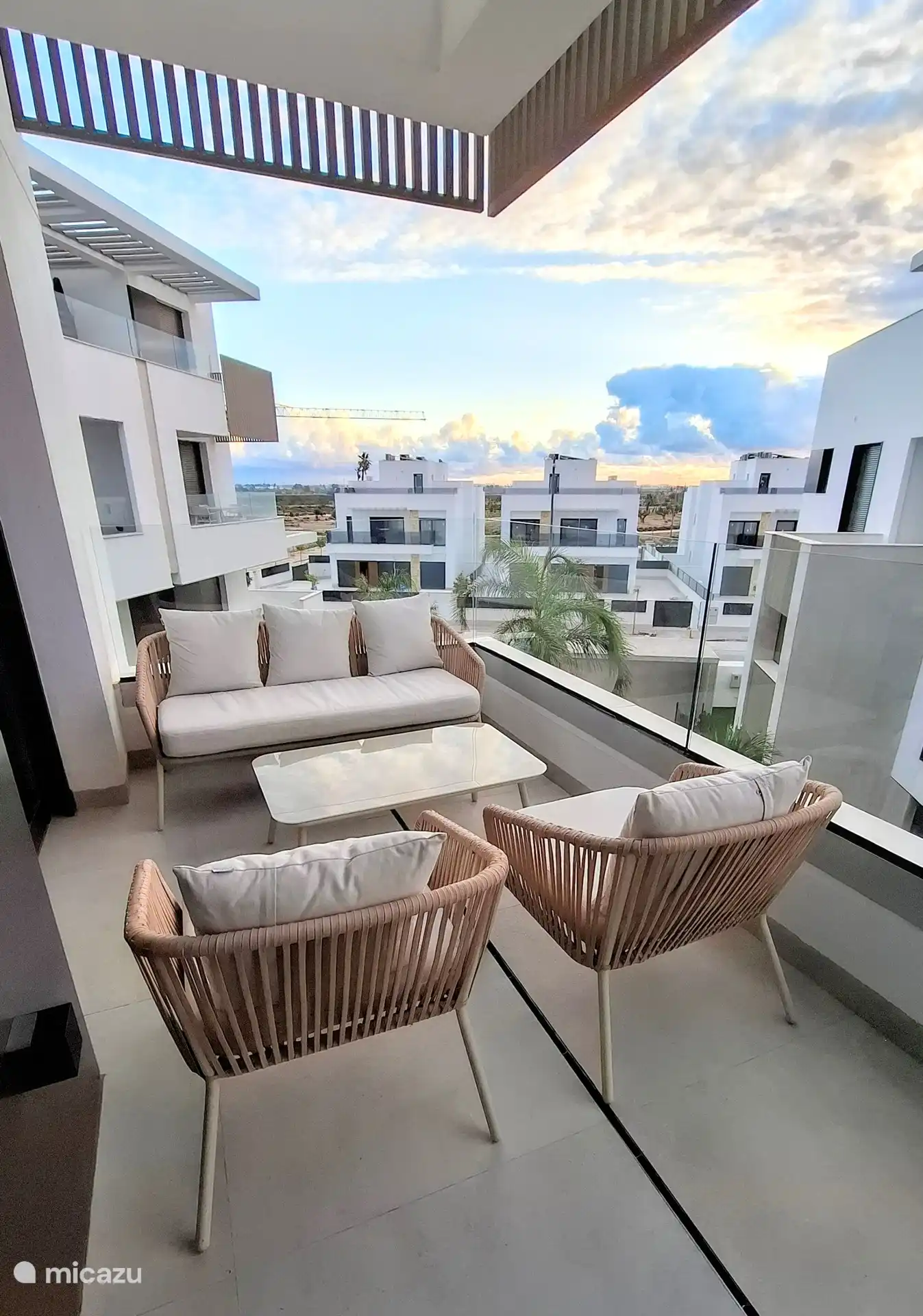 Terraza con un moderno conjunto de salón ideal para tomar un aperitivo y una bebida bajo el sol español