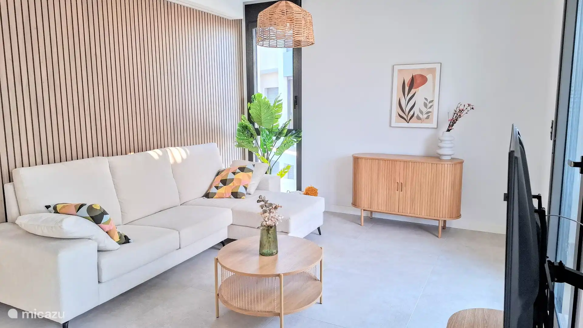 Amplio salón comedor con sofá triple con chaise longue.