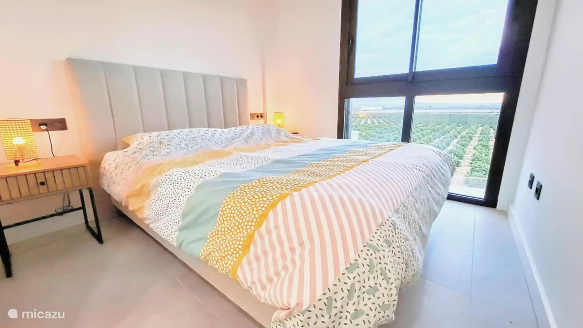 Dormitorio principal con cama de matrimonio (cama doble) y hermosa vista a los campos de cítricos.