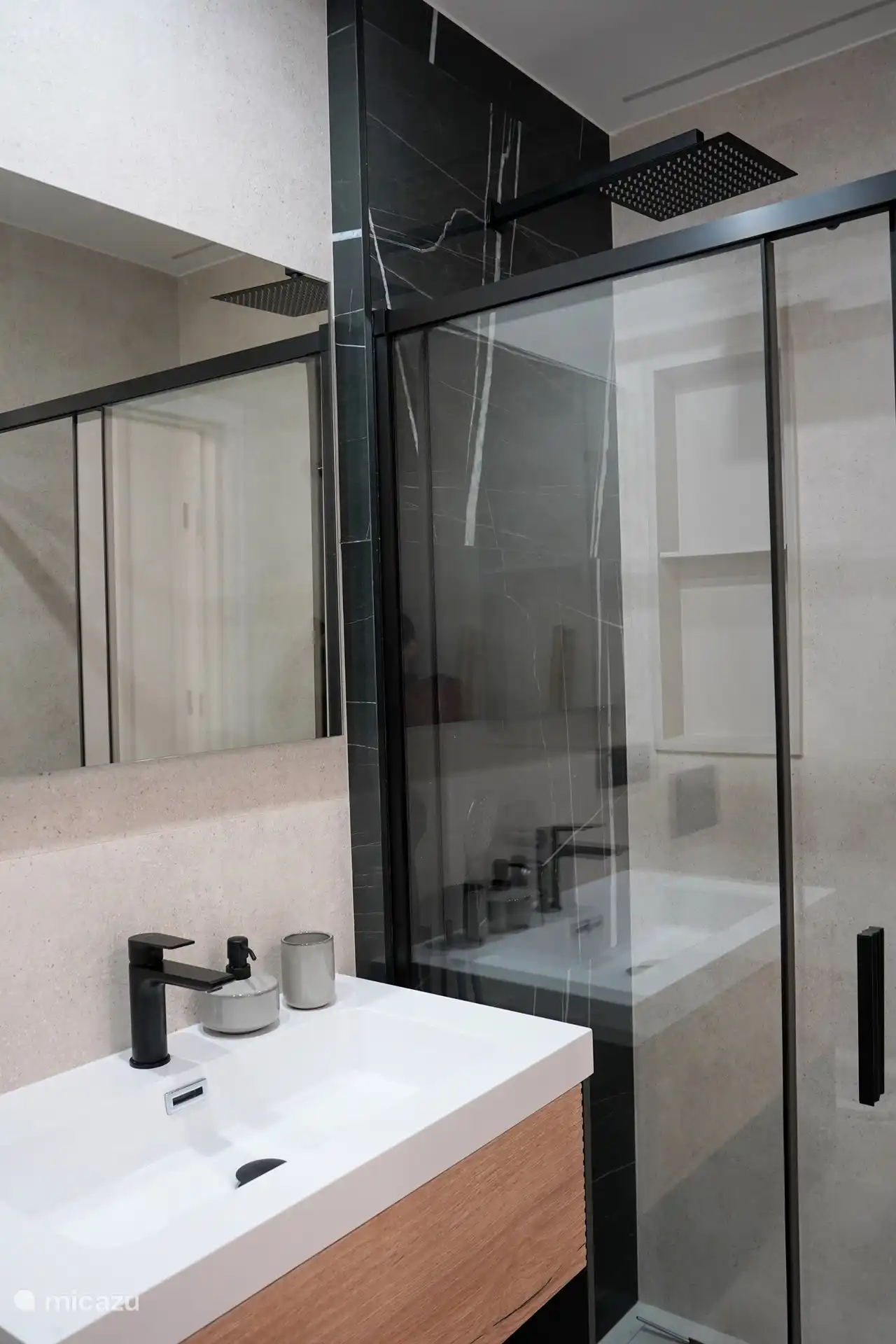 Baño privado en el dormitorio principal con ducha a ras de suelo, inodoro y lavabo.