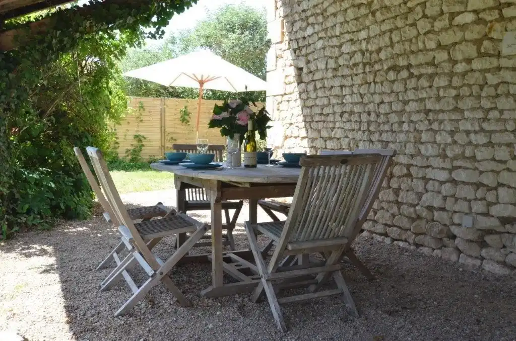 Die überdachte Terrasse, ausgestattet mit einem Teakholztisch und 4 Stühlen.