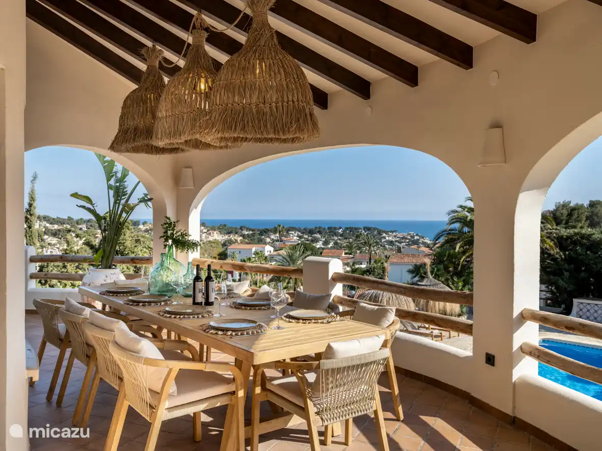 Die 'Naya', überdachte Veranda mit 10-Personen-Tisch und Blick auf das Meer und den Garten mit Swimmingpool