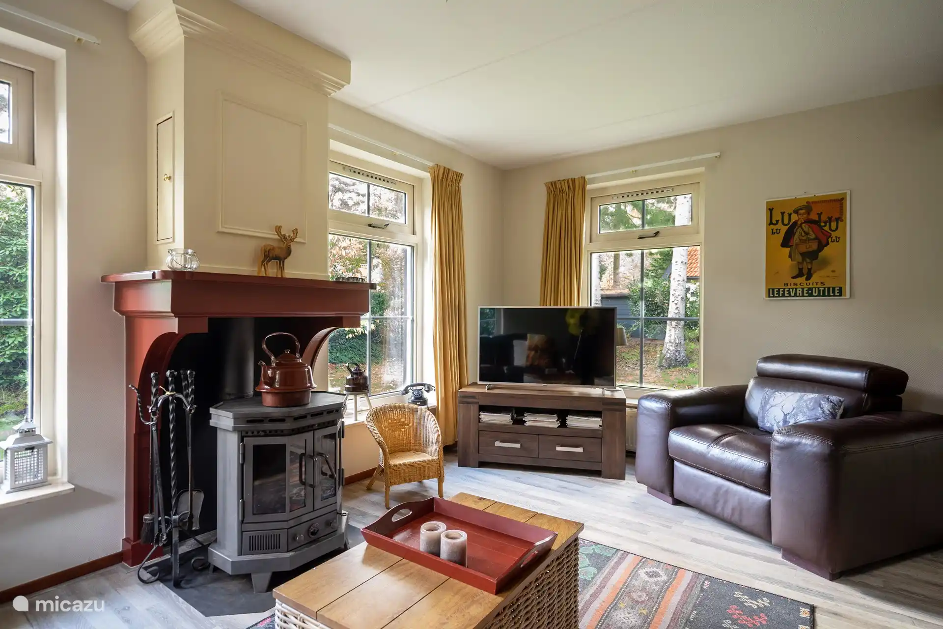 Zimmer im Obergeschoss mit Flachbildschirm, Holzofen und Sitzbereichen