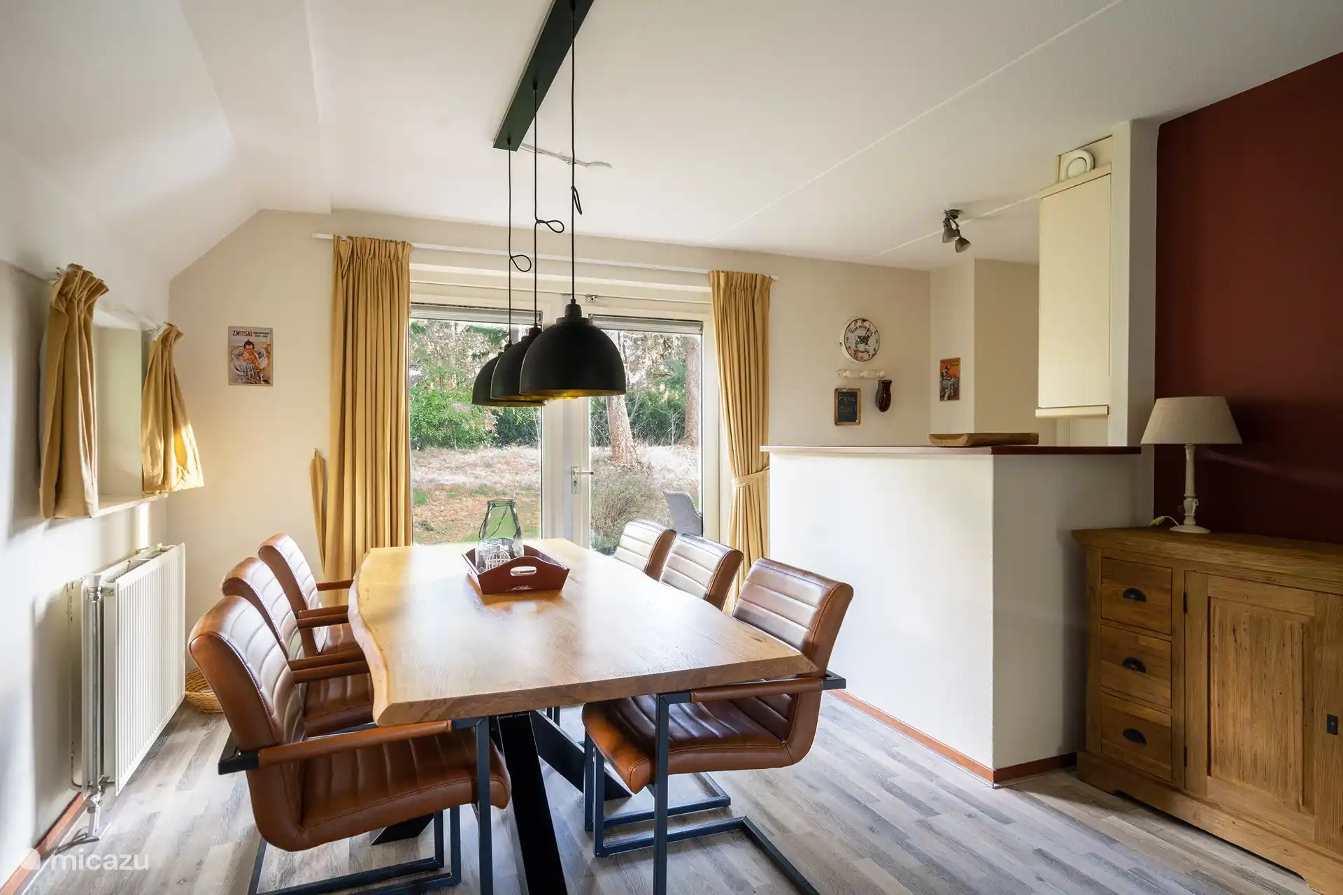 Geräumiges Wohnzimmer mit Esszimmer und Terrassentüren zur Terrasse und zum Hinterhof. Auf der rechten Seite Bar mit offener Küche.