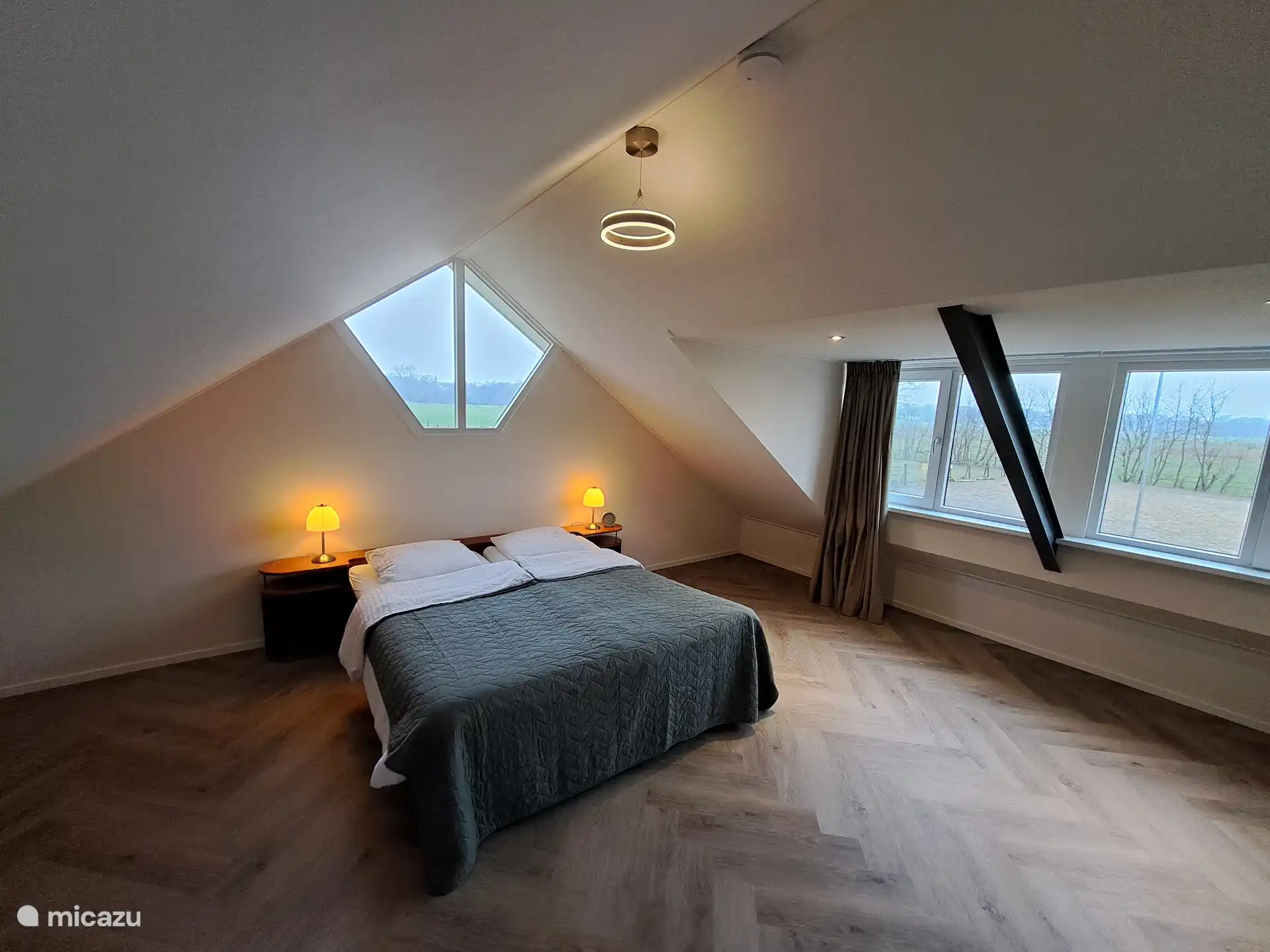 Chambre à l’étage avec une vue dégagée sur les prairies et la réserve naturelle. Au loin, vous pouvez voir la tour du château de Cloese
