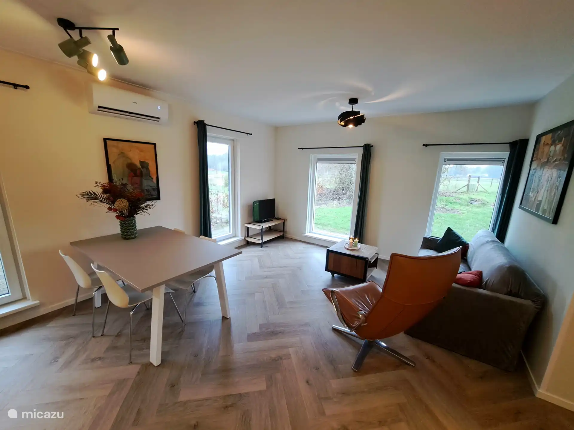 Salon avec table à manger, coin salon et climatisation