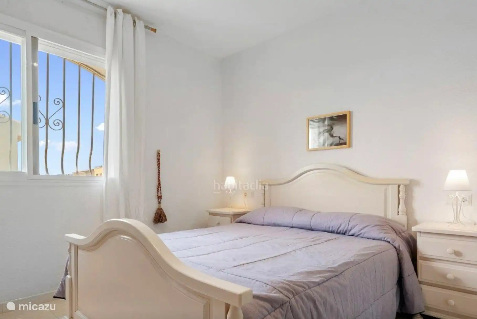 Bedroom with double bed, large built-in wardrobe and access to spacious bathroom.