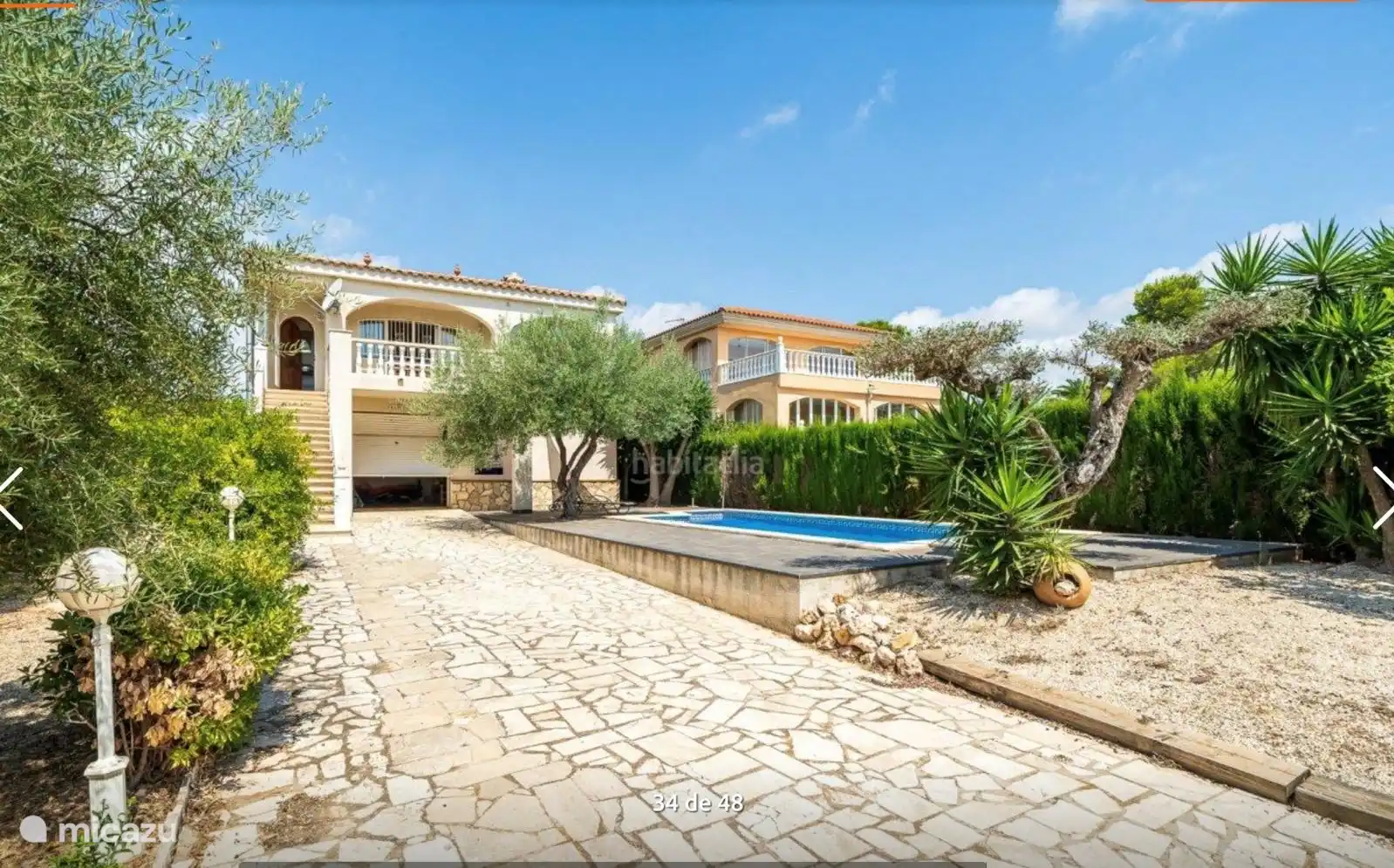 Front garden with driveway, sun terrace and large swimming pool.