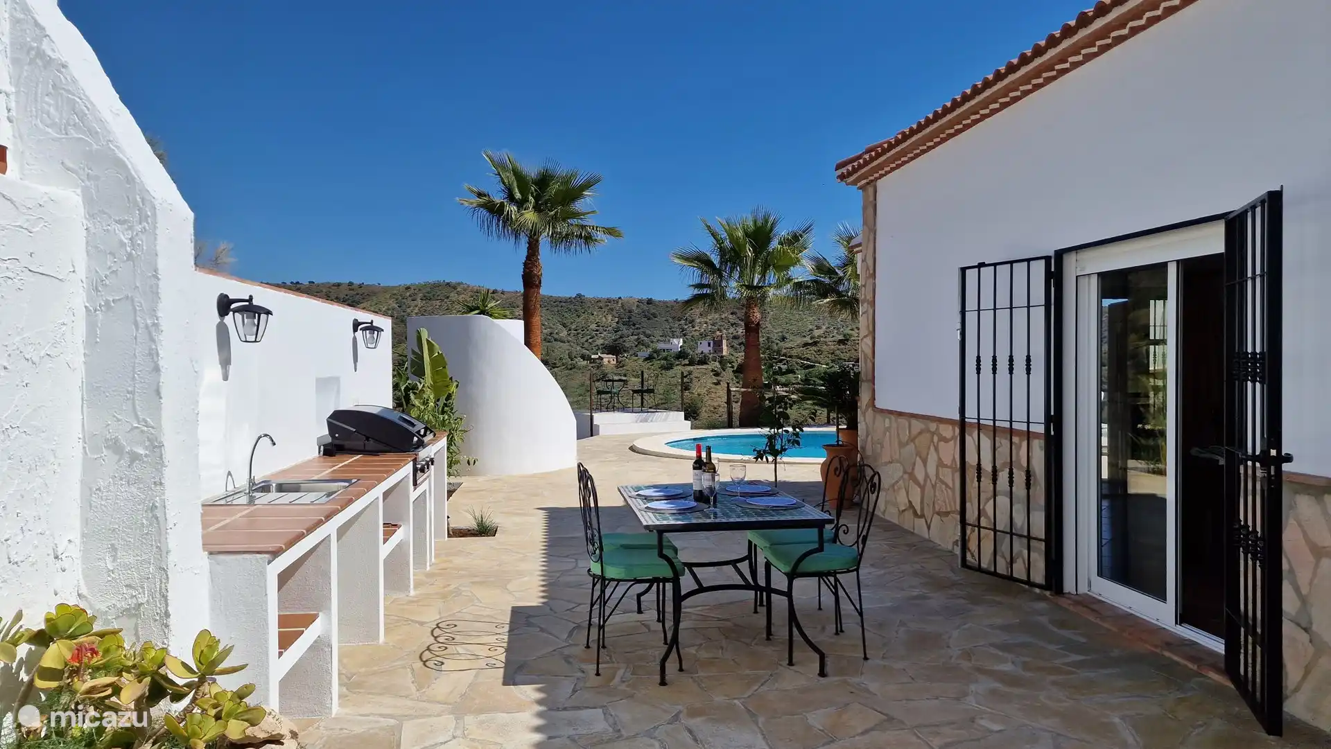 Outdoor kitchen with gas bbq. Curved pool shower in the background.