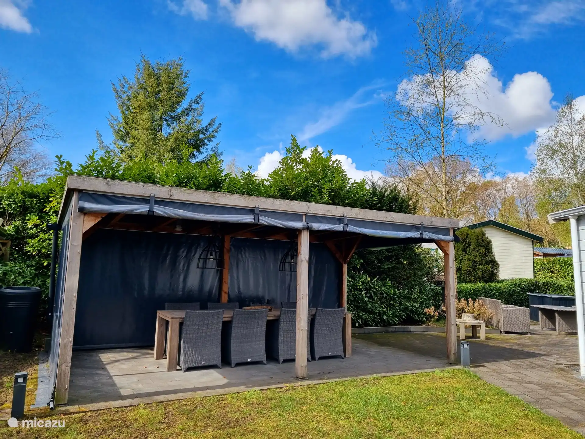 Overkapping met grote eettafel en stoelen