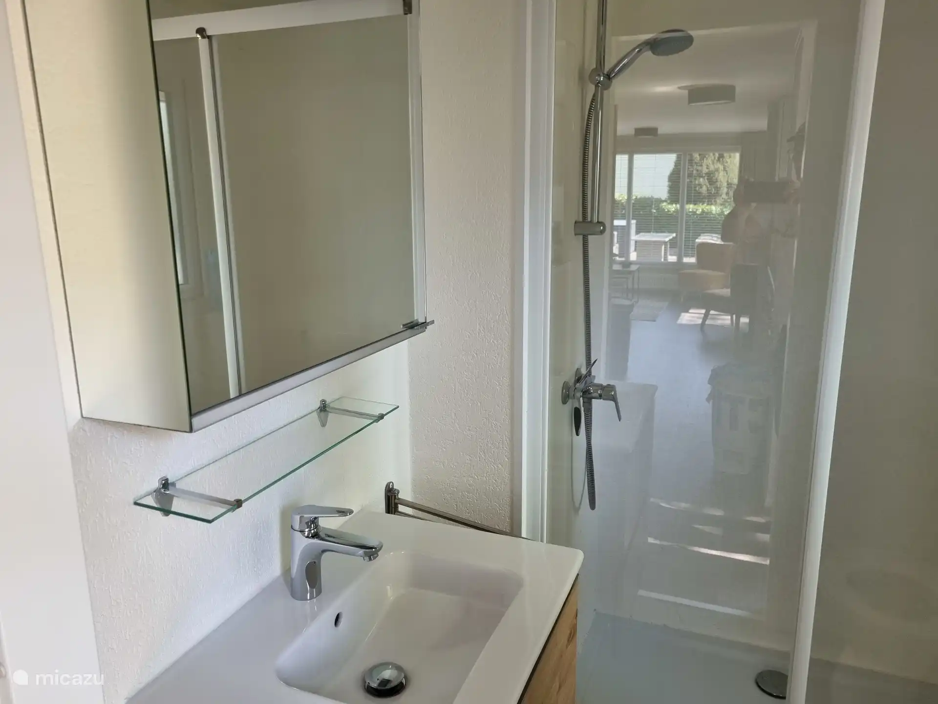 Badkamer met ruime douche, toilet en wastafelmeubel